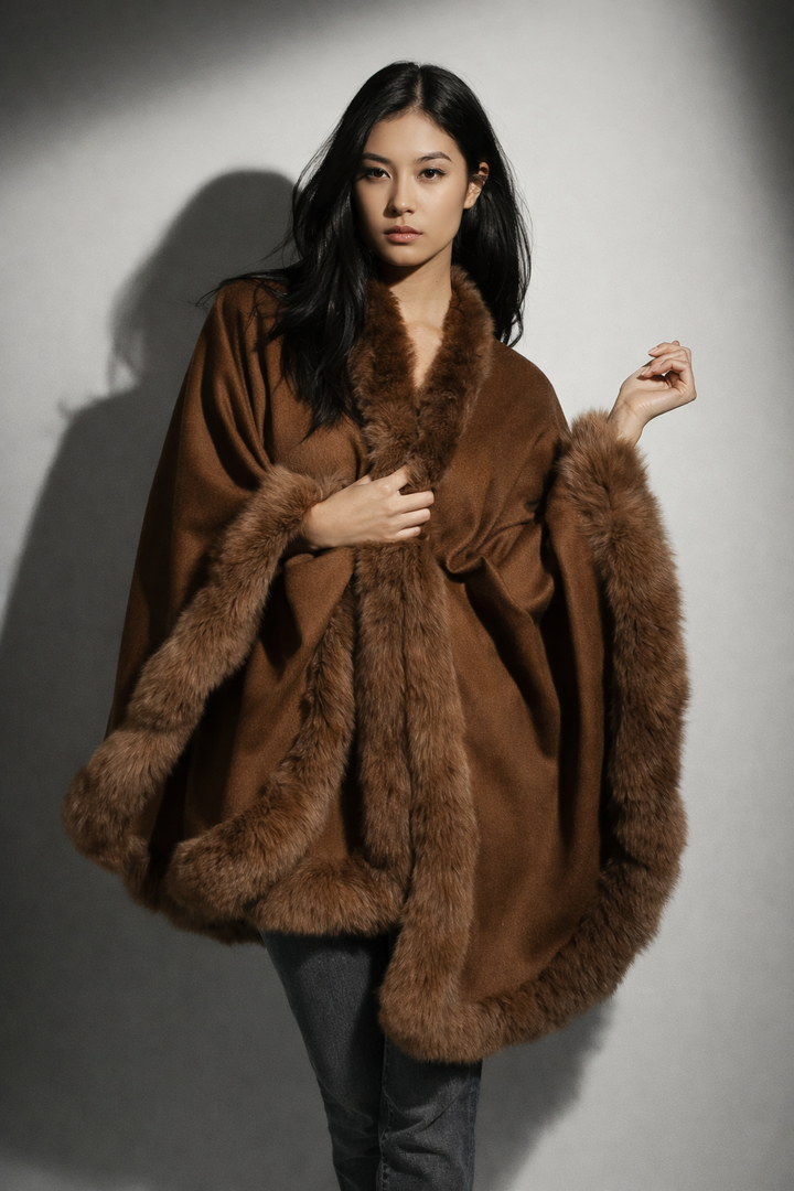 Woman wearing a brown fur-trimmed coat against a plain background