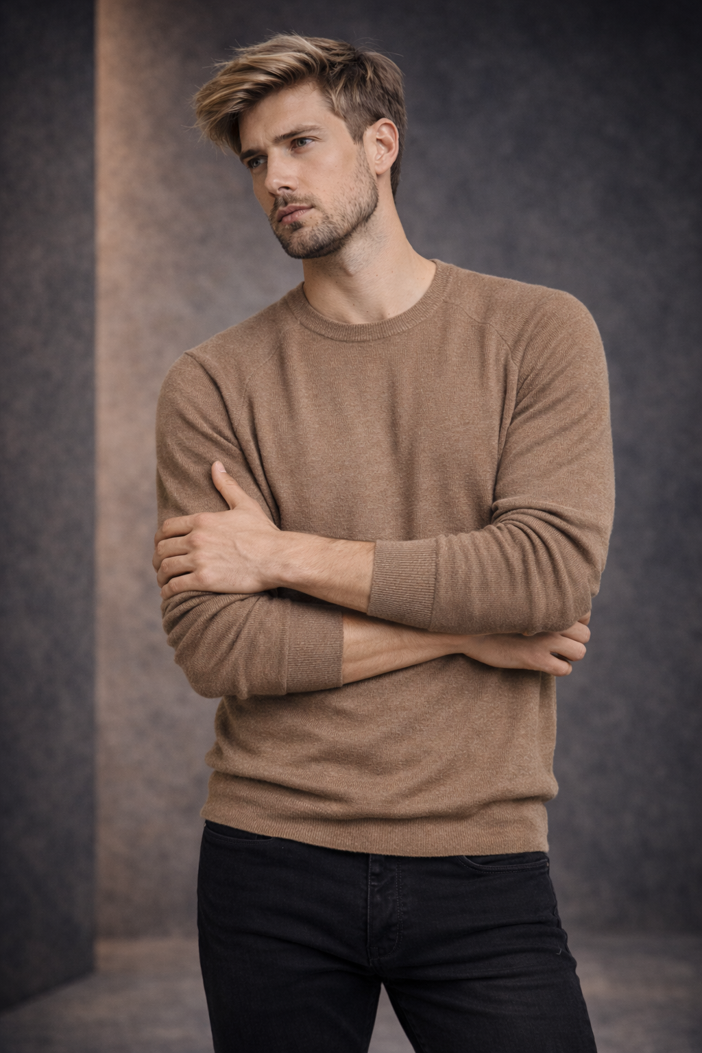 Man wearing a brown sweater against a dark background